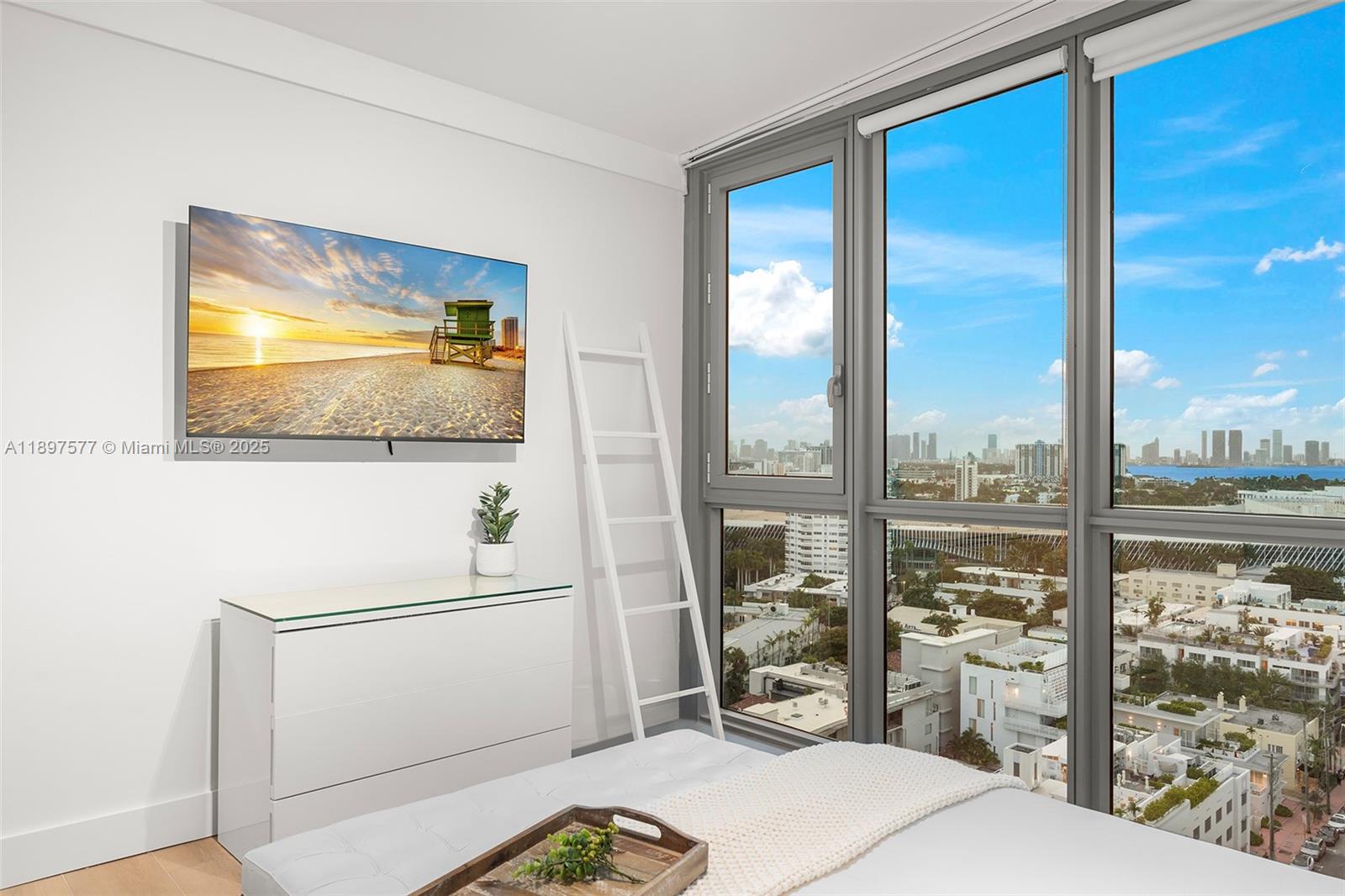 101 20th Street, Unit 2002 Miami Beach, FL 33139 - Photo 19 of 40 a room with a bed and a flat screen tv