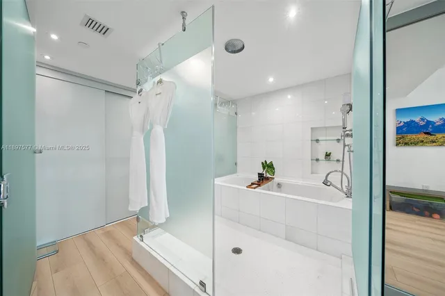 a bathroom with a bathtub sink vanity and mirror