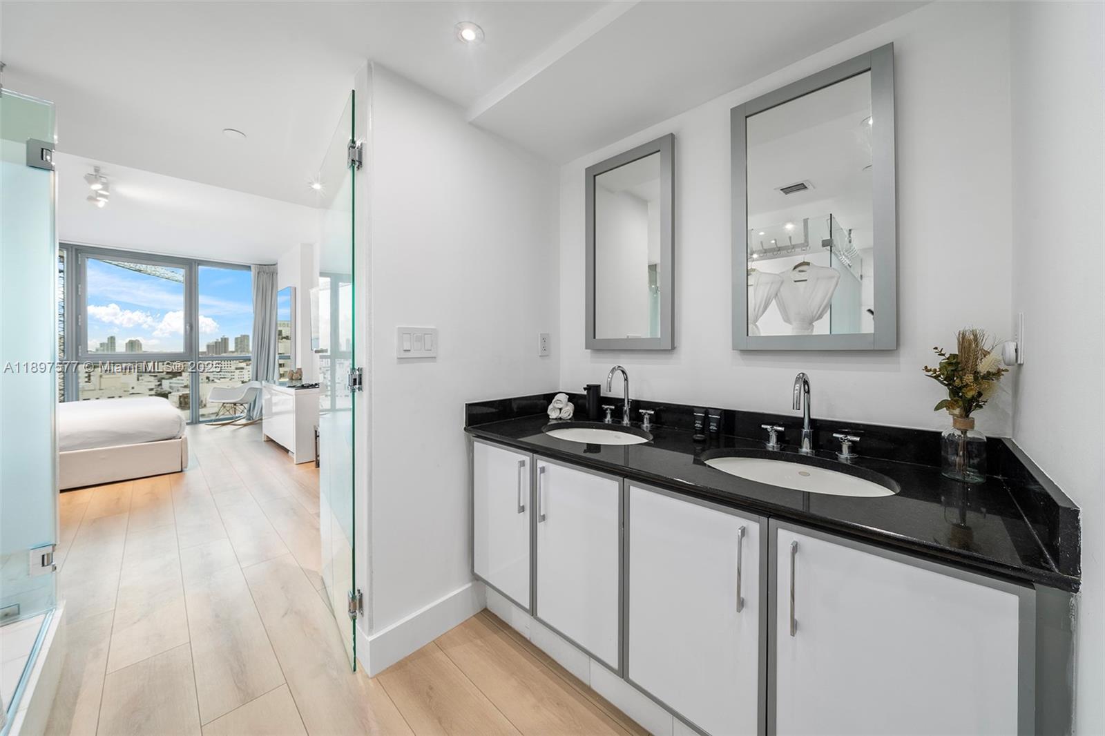 101 20th Street, Unit 2002 Miami Beach, FL 33139 - Photo 36 of 40 a en suite bathroom with a granite countertop sink and a mirror
