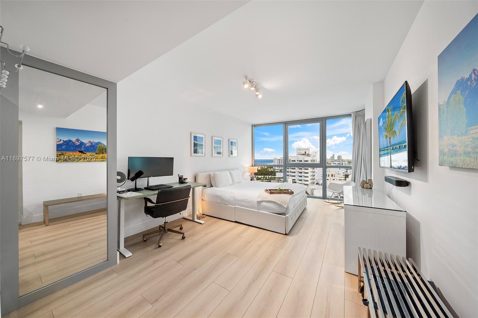 101 20th Street, Unit 2002 Miami Beach, FL 33139 - Photo 4 of 40 a living room with furniture a flat screen tv and a wooden floor