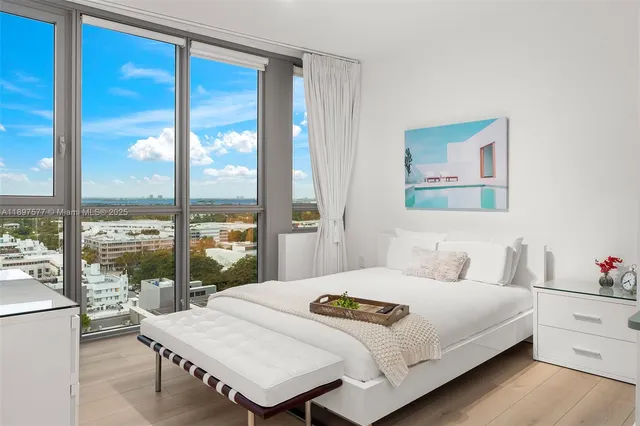 a bedroom with a bed and a large window