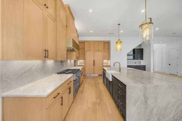 a open kitchen with stainless steel appliances granite countertop a sink a stove and a refrigerator