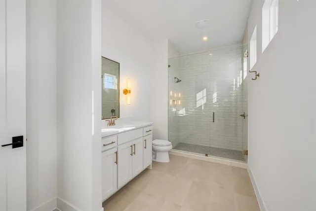 a bathroom with a double vanity sink toilet and shower