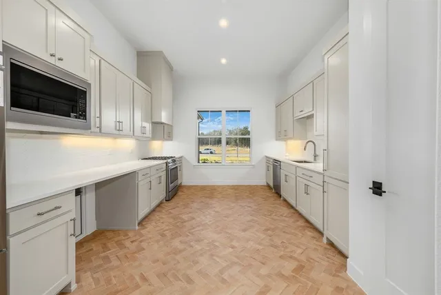 a large white kitchen with cabinets