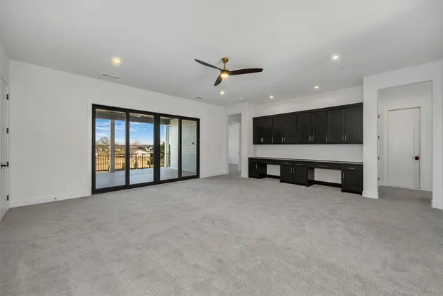 a view of an empty room with a ceiling fan