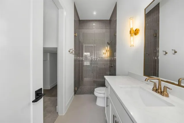 a bathroom with a sink a toilet and shower