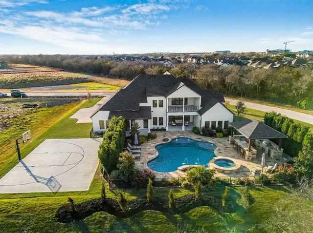 a aerial view of a house with swimming pool garden and lake view