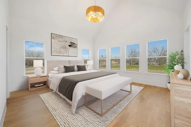 a spacious bedroom with a bed mirror and window