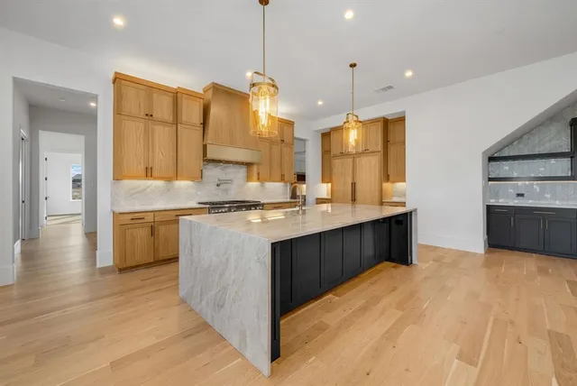 a kitchen with stainless steel appliances kitchen island granite countertop a sink counter space and cabinets