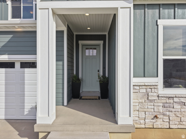 2559 West Aurora Avenue Mapleton, UT 84664 - Photo 3 of 60 Covered front entry featuring a light blue panel door with glass inserts, recessed lighting, and a composite wood-look ceiling