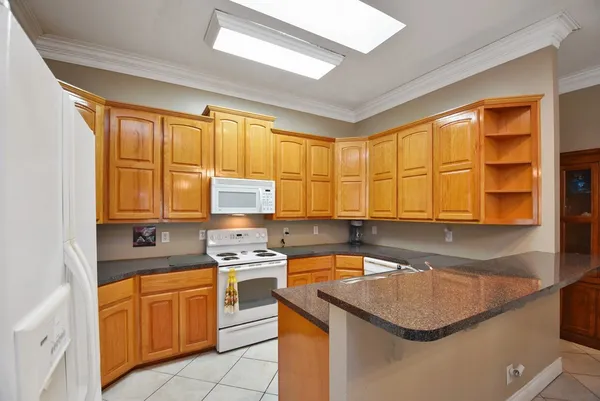 a kitchen with stainless steel appliances granite countertop a sink a stove and a refrigerator