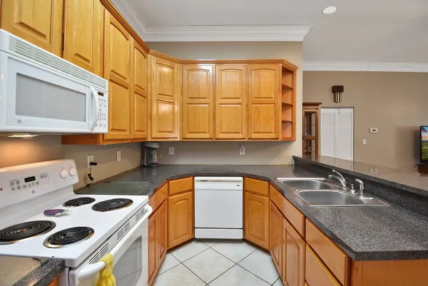 a kitchen that has a sink a stove and a microwave