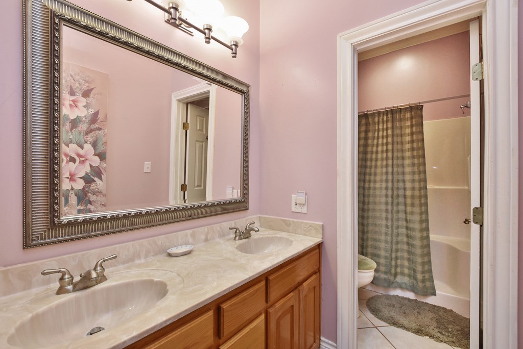 208 East 20th Street Cameron, TX 76520 - Photo 10 of 20 a bathroom with a sink a toilet a mirror and shower