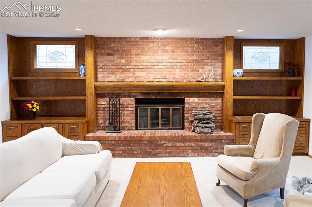 555 Hidden Marsh Road Monument, CO 80132 - Photo 11 of 47 a living room with furniture a flat screen tv and a fireplace