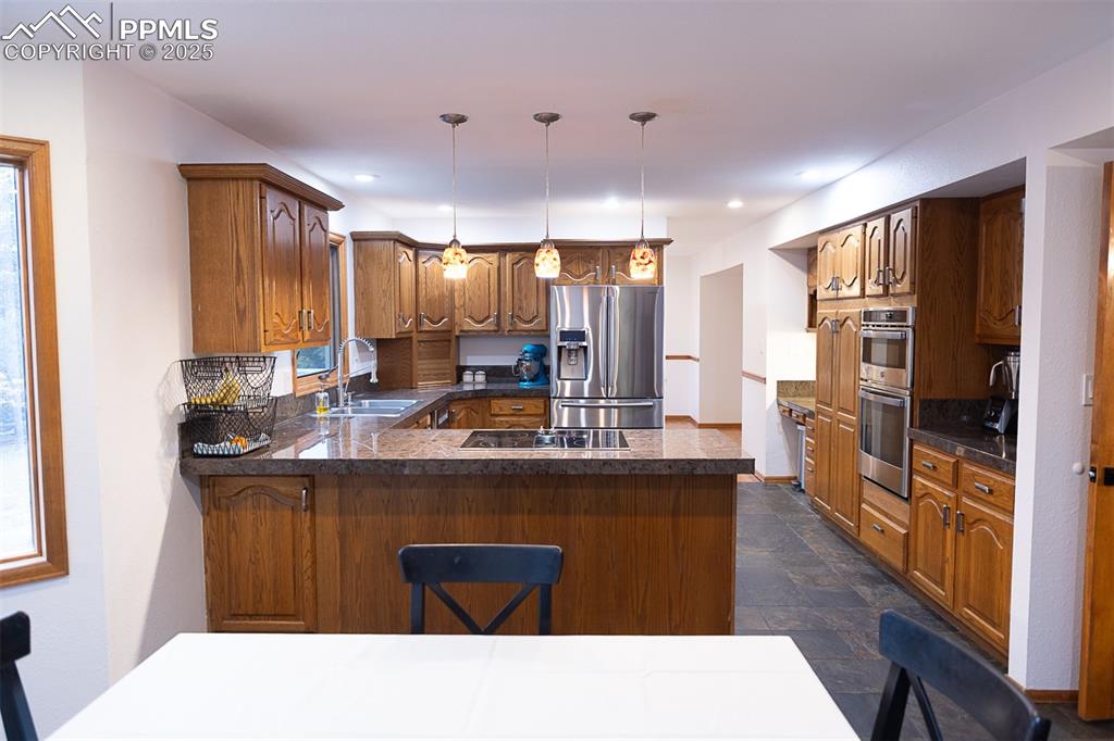 555 Hidden Marsh Road Monument, CO 80132 - Photo 18 of 47 a kitchen with kitchen island a sink stove and refrigerator