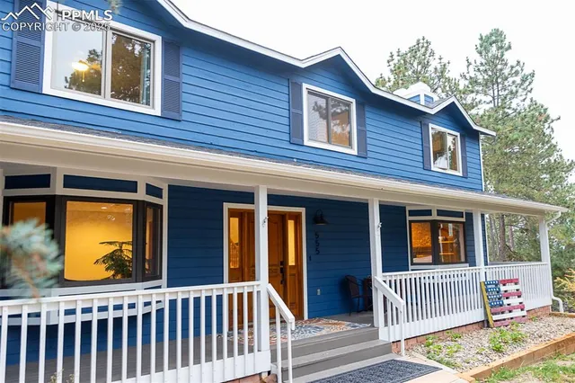 a view of a house with a small yard and wooden fence