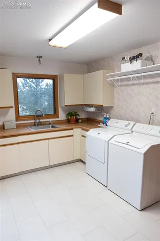 a utility room with cabinets washer and dryer