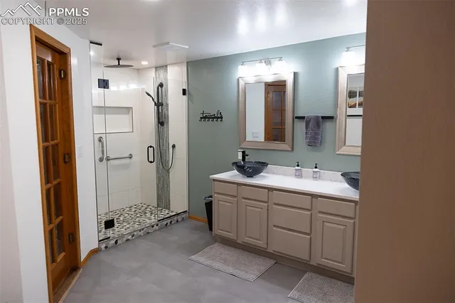 a bathroom with a double vanity sink mirror and shower