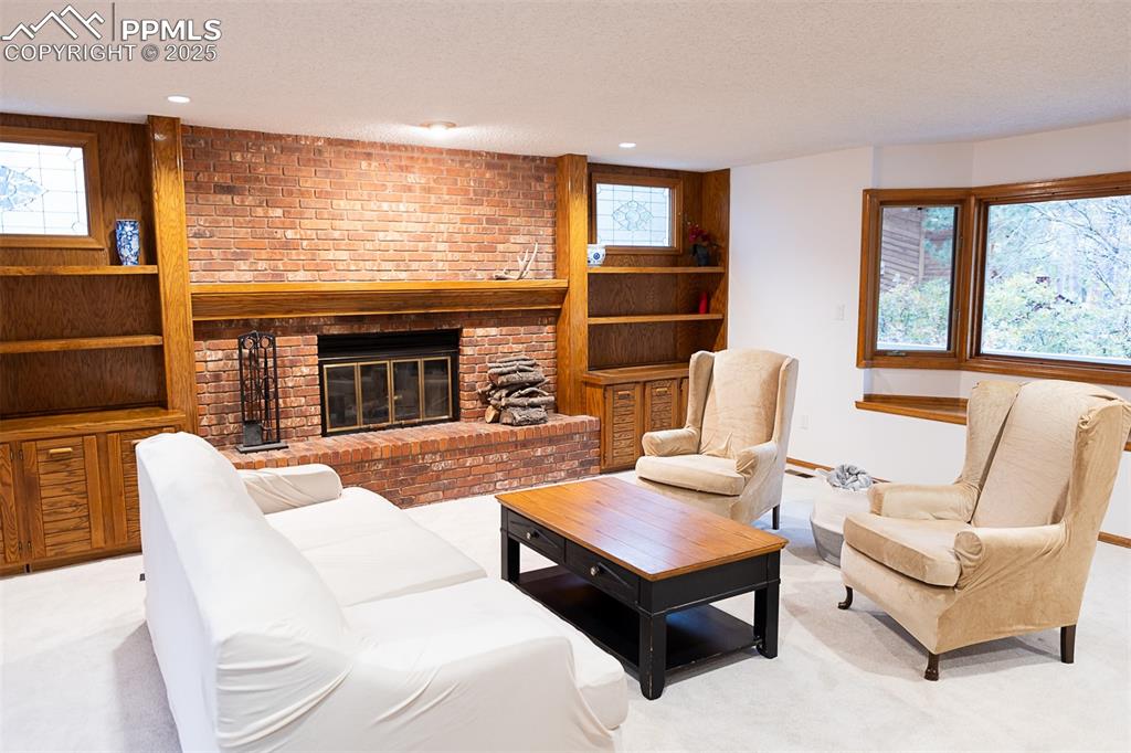 555 Hidden Marsh Road Monument, CO 80132 - Photo 9 of 47 a living room with furniture a fireplace and a large window