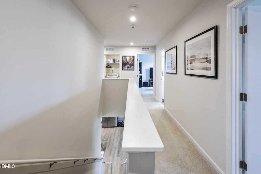 4468 Captain Falls Drive Raleigh, NC 27610 - Photo 22 of 36 a view of hallway with furniture and wooden floor