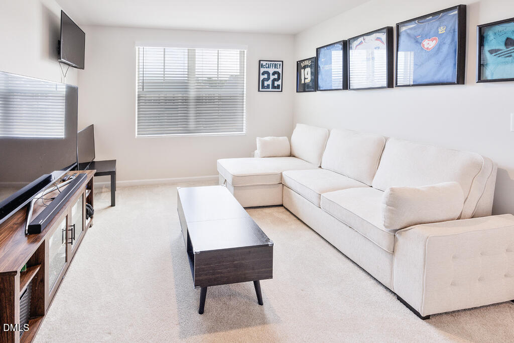 4468 Captain Falls Drive Raleigh, NC 27610 - Photo 24 of 36 a living room with furniture and a flat screen tv