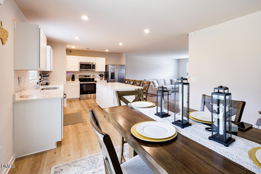 4468 Captain Falls Drive Raleigh, NC 27610 - Photo 4 of 36 a view of a dining room with furniture a rug and wooden floor