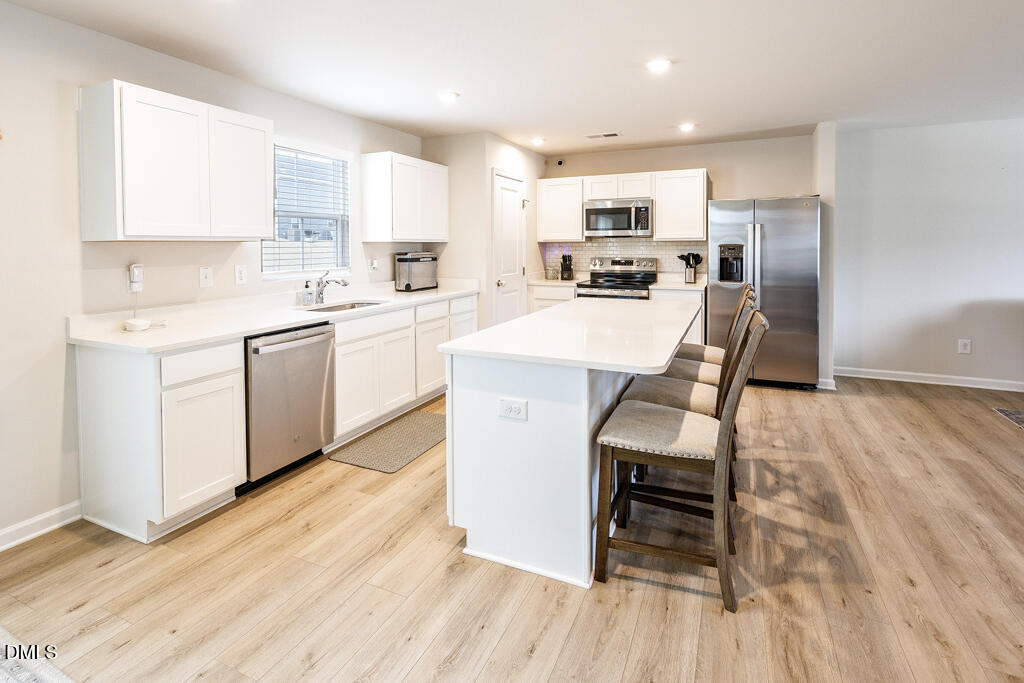 4468 Captain Falls Drive Raleigh, NC 27610 - Photo 6 of 36 a kitchen with a sink a counter top space stainless steel appliances and cabinets