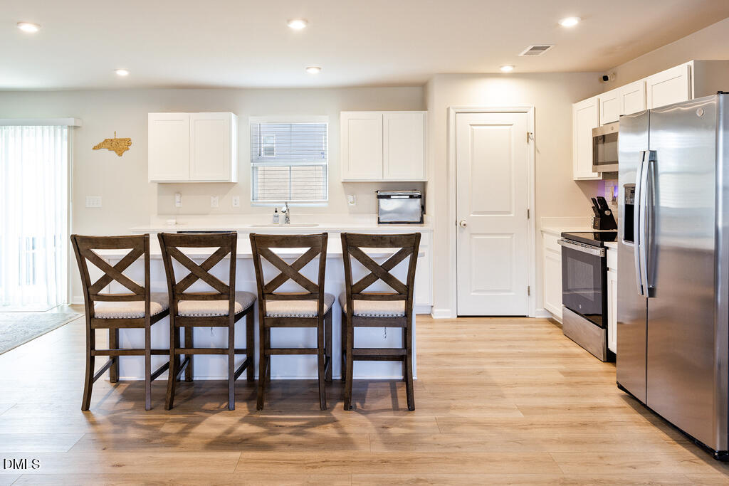 4468 Captain Falls Drive Raleigh, NC 27610 - Photo 7 of 36 a kitchen with granite countertop a refrigerator and wooden floor