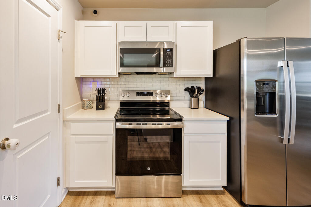 4468 Captain Falls Drive Raleigh, NC 27610 - Photo 9 of 36 a kitchen with a refrigerator stove and microwave