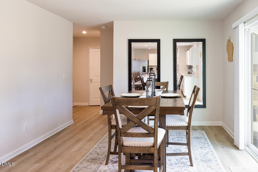 4468 Captain Falls Drive Raleigh, NC 27610 - Photo 10 of 36 a view of a dining room with furniture and wooden floor