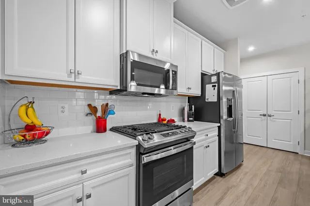 a kitchen with stainless steel appliances a stove microwave and refrigerator