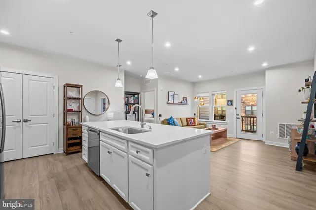 a kitchen with a sink stove and wooden floor