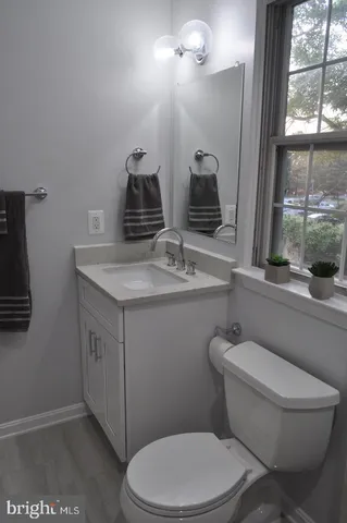 a bathroom with a granite countertop toilet sink and mirror