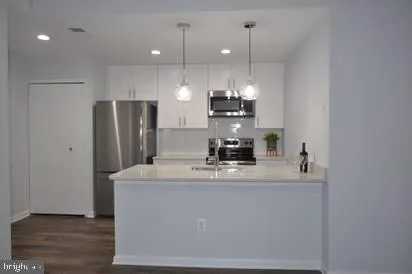 a kitchen with kitchen island a refrigerator and a stove