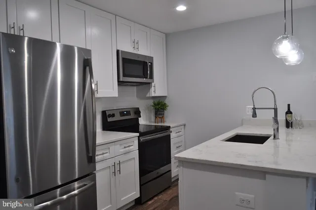 a kitchen with a refrigerator sink and cabinets