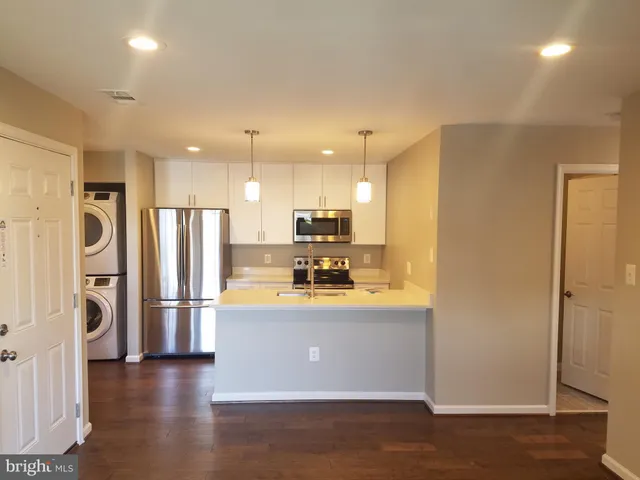 a view of kitchen with stainless steel appliances refrigerator oven and cabinets
