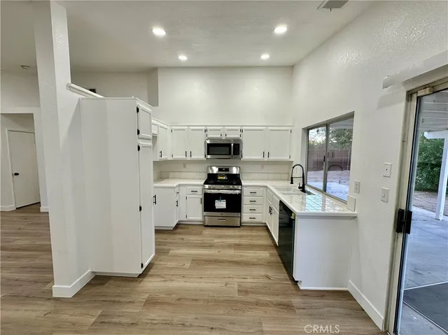 a large kitchen with a large counter top appliances and cabinets