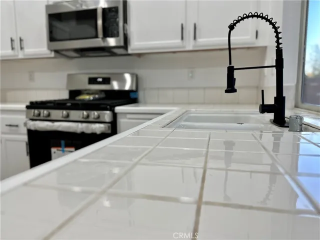 a kitchen with stainless steel appliances kitchen island granite countertop a stove a sink and a microwave