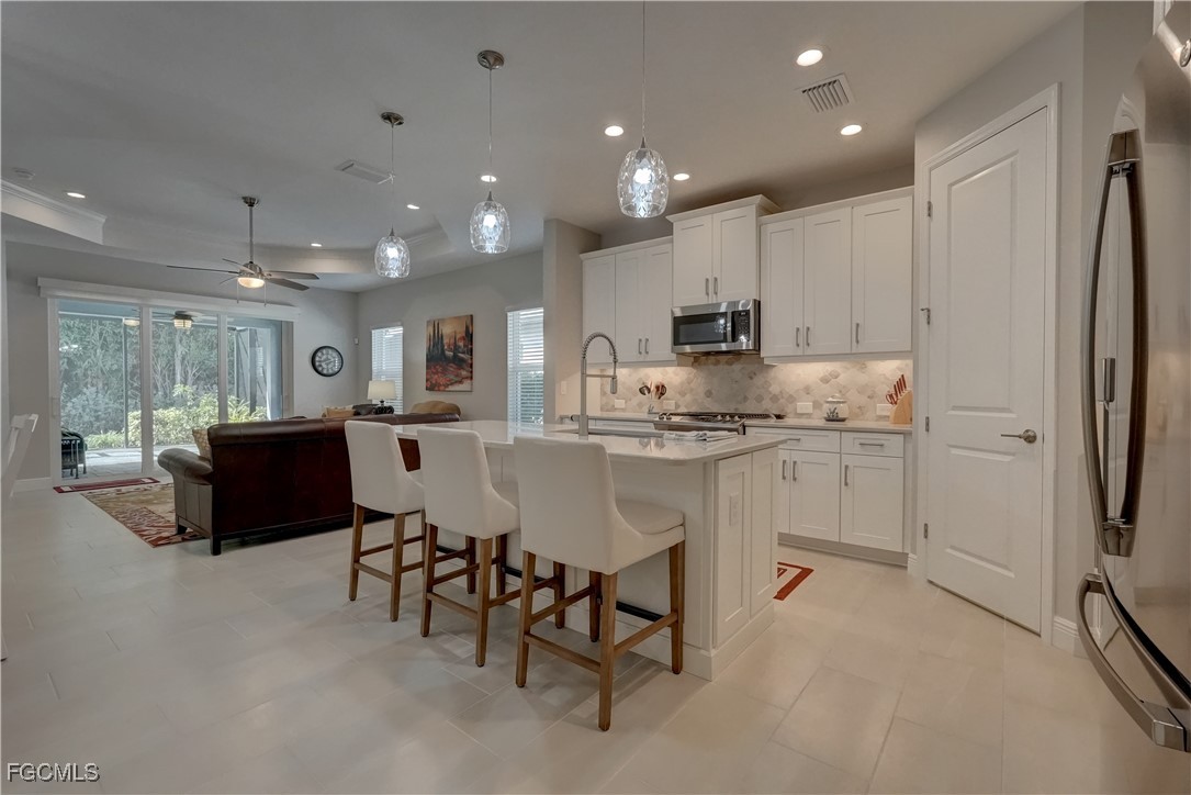 a kitchen with kitchen island white cabinets and stainless steel appliances