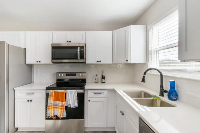a large kitchen with cabinets wooden floor and stainless steel appliances
