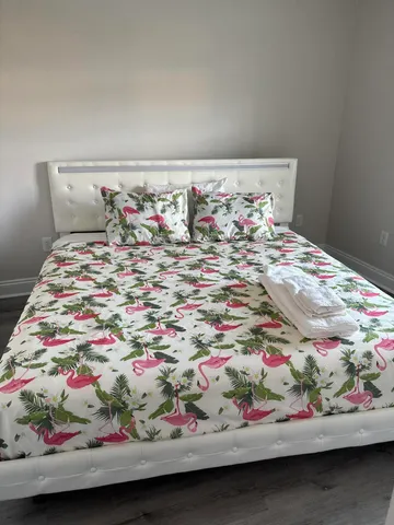 a bedroom with a white bed and a ceiling fan