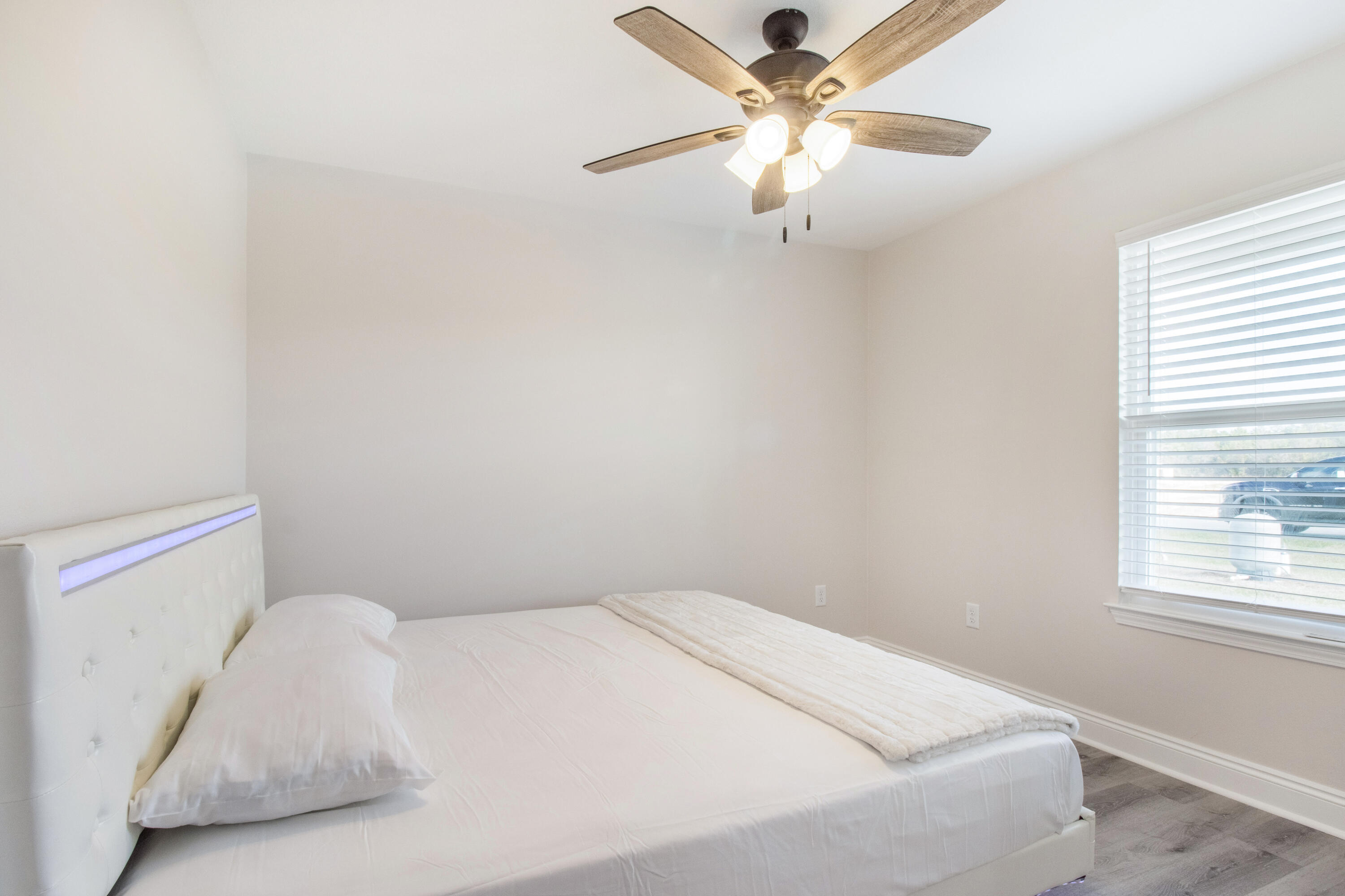 5374 Highview Drive Crestview, FL 32539 - Photo 8 of 12 a bedroom with a white bed and a ceiling fan