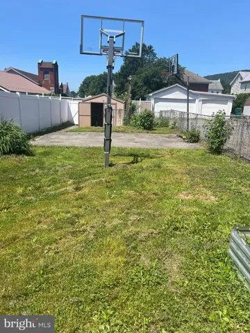 a kitchen with granite countertop a stove a refrigerator and a microwave oven with wooden floor