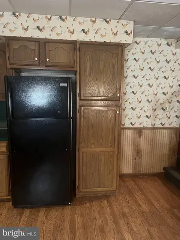 a living room with a mirror and wooden floor