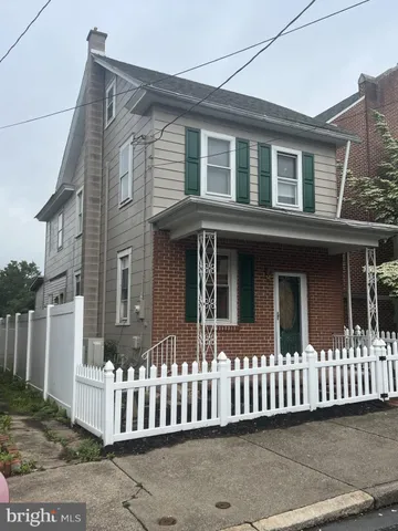 a view of a house with a yard and potted plants