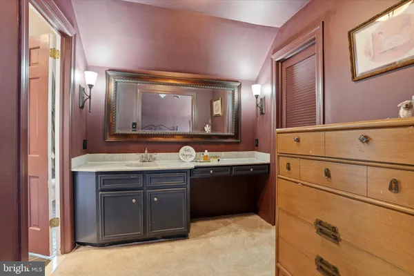 a bathroom with a granite countertop double vanity sink and mirror