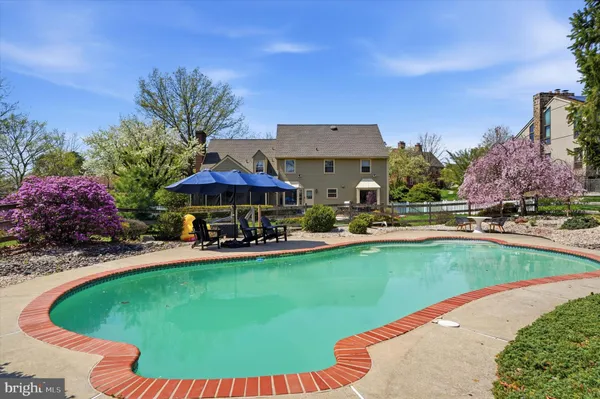 a view of a swimming pool with lawn chairs under an umbrella
