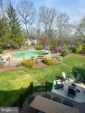 a view of a swimming pool and lounge chairs in back yard of the house