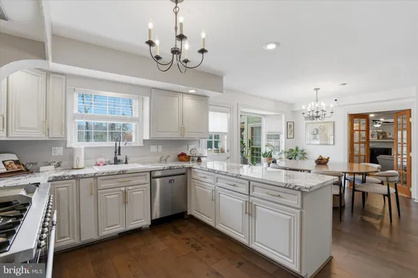 a large white kitchen with a sink and cabinets