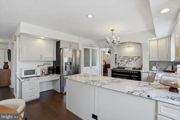 a large kitchen with kitchen island a sink stainless steel appliances and cabinets